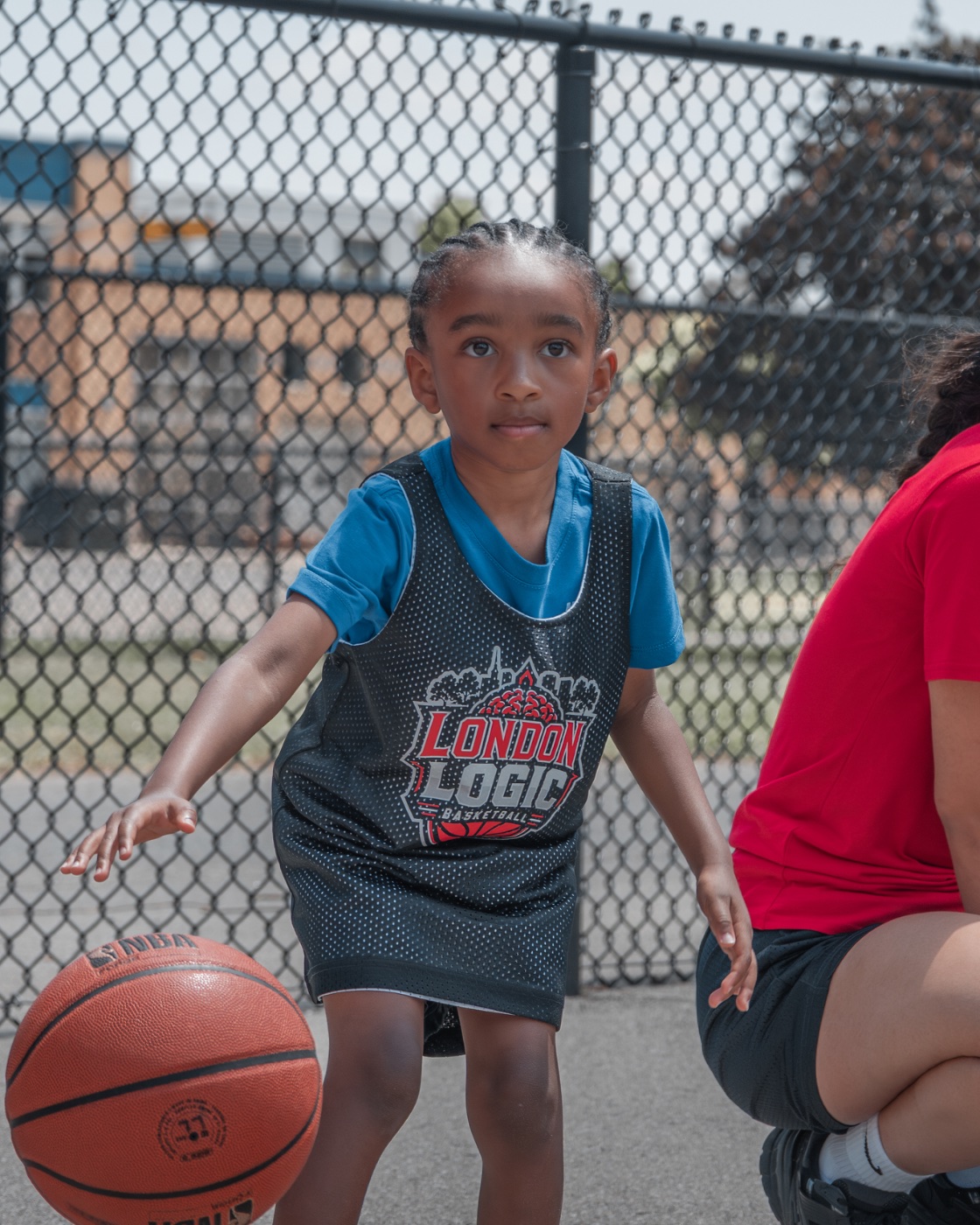 A young London LOGIC athlete dribbling at camp, focused and determined